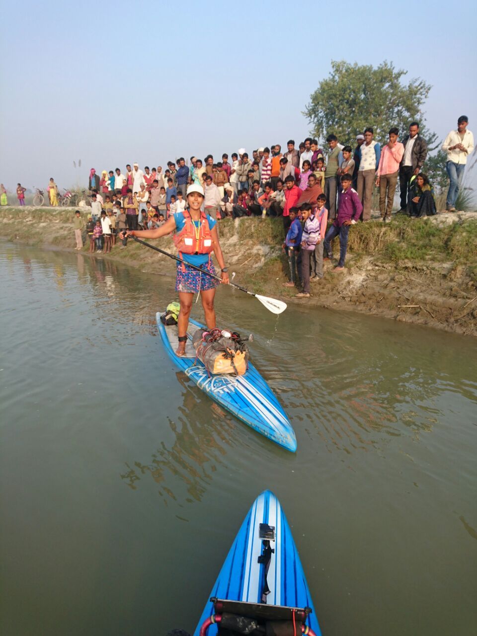 Men and boys see the team paddle off in the morning in Uttar Pradesh. Photo © Pascal Dubois